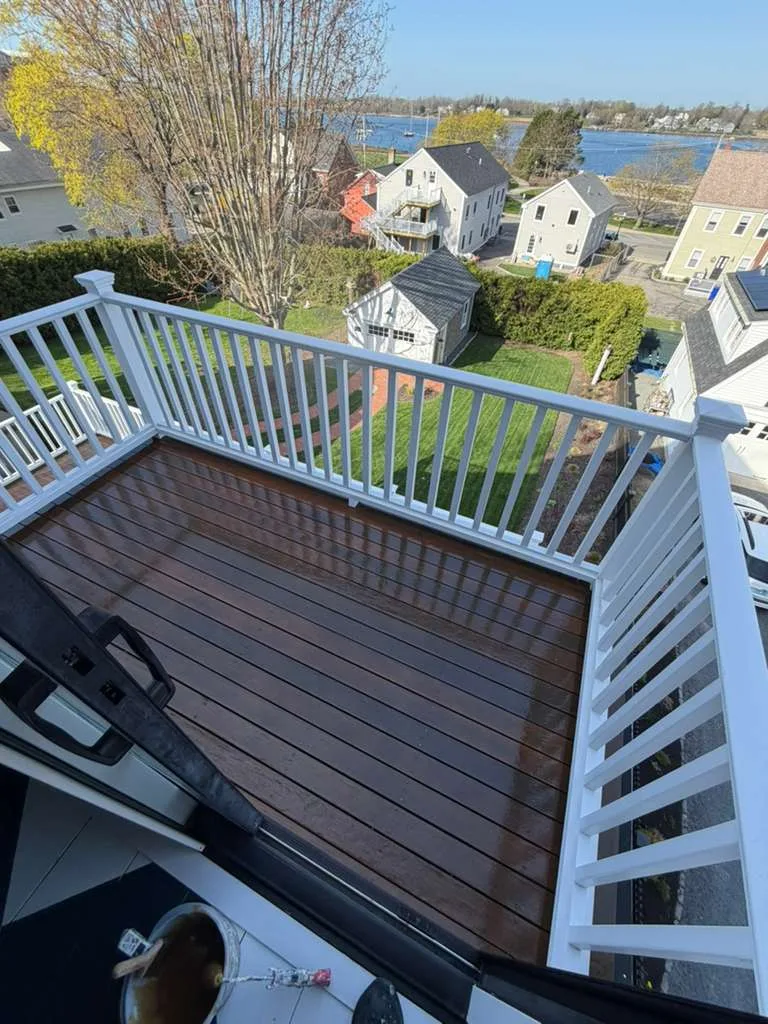 Aerial view of a balcony after professional Ipe deck refinishing, highlighting the rich wood tone against a white railing.